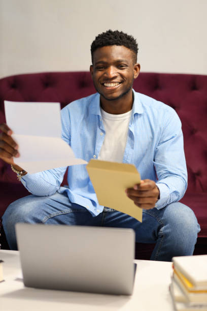 istock Happy African guy received an invitation in the mail. 1576110960