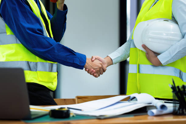 istock Civil engineers and architects handshake after work done at the office and hold the hard hat 1576114842