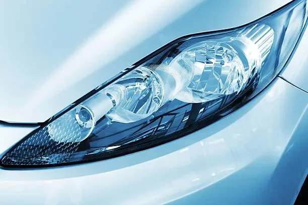 Close up of the right headlight from a new modern car with HALOGEN technologie. There are several Light technics for cars on the market: Xenon headlights, a gasdischarge lamp emit a strong bluish light, which is sometimes perceived as dazzling. Halogen headlights: The yet most widely used light source. For  LASER LIGHT you need high voltage and are therefore not yet available for all vehicle types. LED headlights have the benefits are to be smaller with better energy consumption and longer life