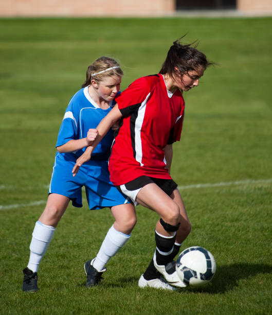 istock Young Female Soccer Player Sheilds Ball from Defender 157611670