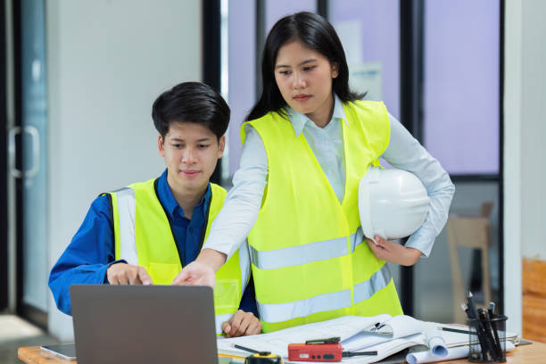 istock Civil engineers and architects discuss project construction together on laptop at the office and holding hard hat 1576117607