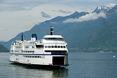 A ferry sailing through a waterway surrounded by hills