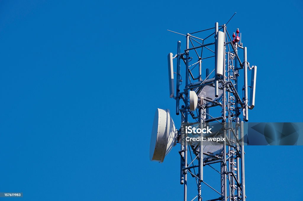 Mobile phone antenna close up against deep blue clear sky Telecommunication tower for cell phone network coverage. UMTS, GSM, GPRS, cell phone transmitter. Isolated against blue. GPRS Stock Photo