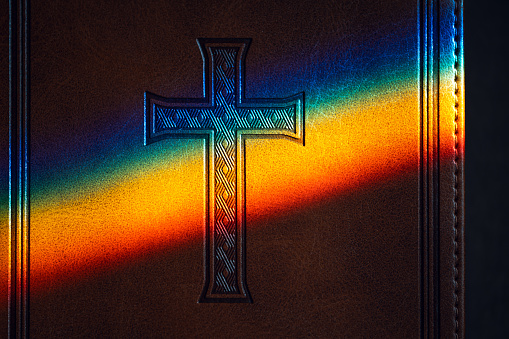 Holy Bible with LGBT rainbow reflection