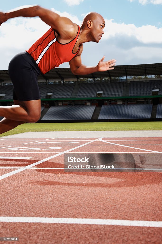 Macho en línea inicial de atleta de pista de atletismo - Foto de stock de Correr libre de derechos