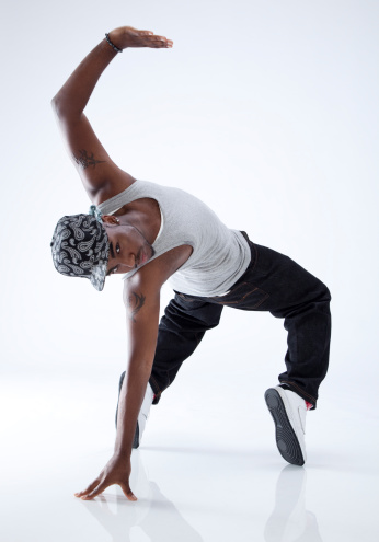 breakdancer on his toes, doing a back bend on one hand, on white background