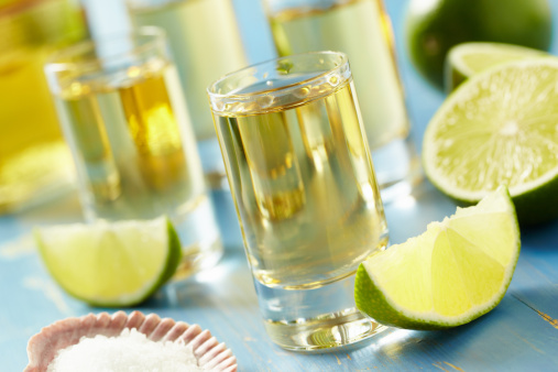 Tequila shots with salt and lime.  Shot with shallow focus on front glass.