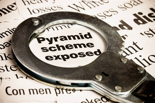 Closed handcuff on headline: pyramid scheme exposed  ponzi scheme stock pictures, royalty-free photos & images