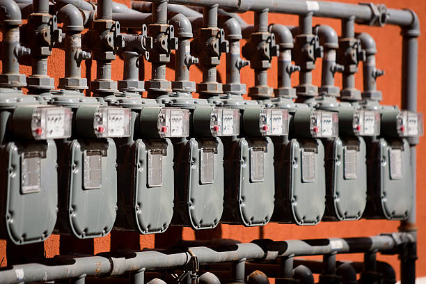 Several Natural Gas Meters in a Row on Orange Wall stock photo