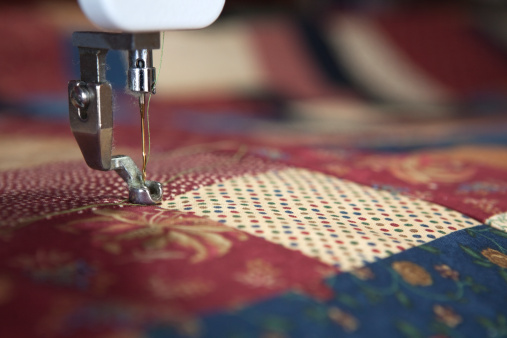Sewing a quilt with quilting machine. Shallow depth of field.