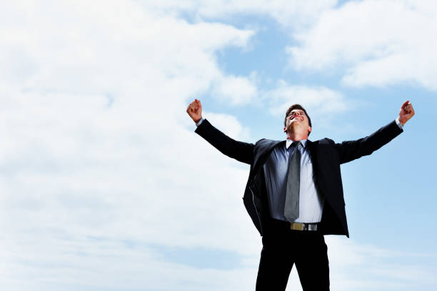 istock Happy business man with arms wide open against sky 157613342