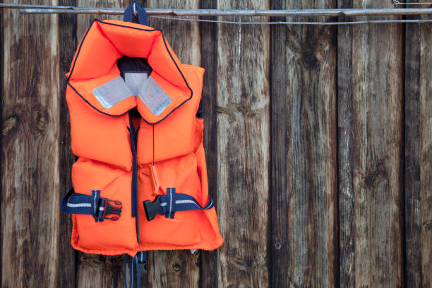 Life jacket for a child against an old wooden wall. Life jacket for a child against an old wooden wall. life jacket stock pictures, royalty-free photos & images