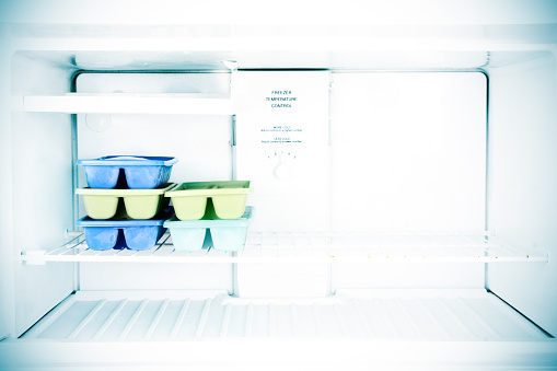 Ice cube trays sit in a freezer.