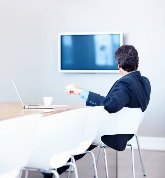 istock Male executive looking at television in a board room 157613580