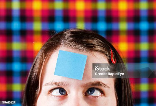 Crosseyed Girl Looking Up At Blank Message On Her Forehead Stock Photo - Download Image Now