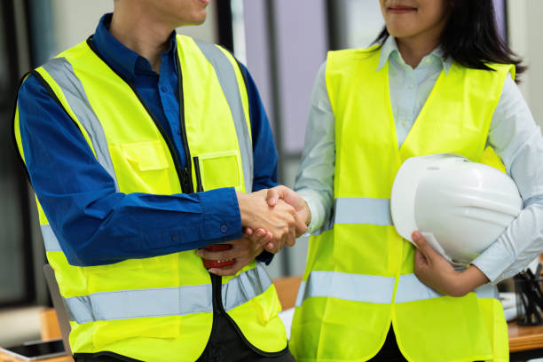 istock Civil engineers and architects handshake after work done at the office and hold the hard hat 1576136740