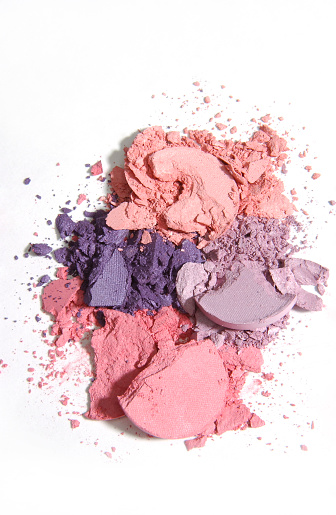 Different crushed eye shadows on pink background, flat lay. Space for text