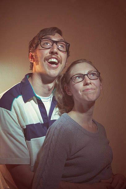 Vintage Portrait Photographs A nerd couple from the 1960s or 1970s poses for a family picture.  Intentional low contrast and washed out brown effect for aged feel and style.  Vertical. nerd sweater stock pictures, royalty-free photos & images