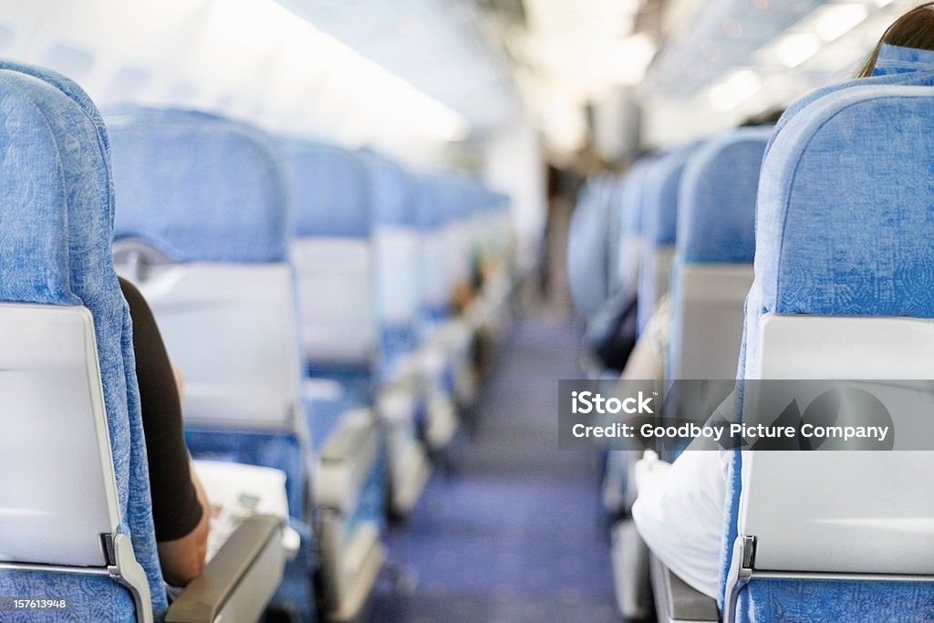 I passeggeri seduti in un aeroplano - Foto stock royalty-free di Aeroplano