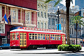 New Orleans Bright Red Streetcar Traveling Amid Palms and Flags