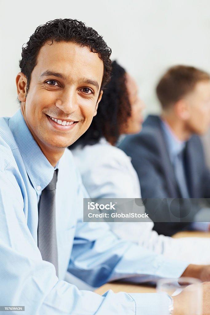 Homme d'affaires assis avec des collègues dans une configuration salle de conseils - Photo de 20-24 ans libre de droits