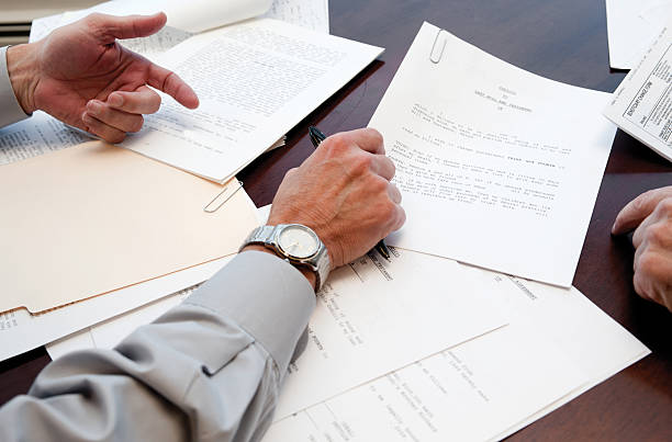 signing will codicil to a last will and testament and irrevocable trust being signed by a 67 year old man.  legal document stock pictures, royalty-free photos & images