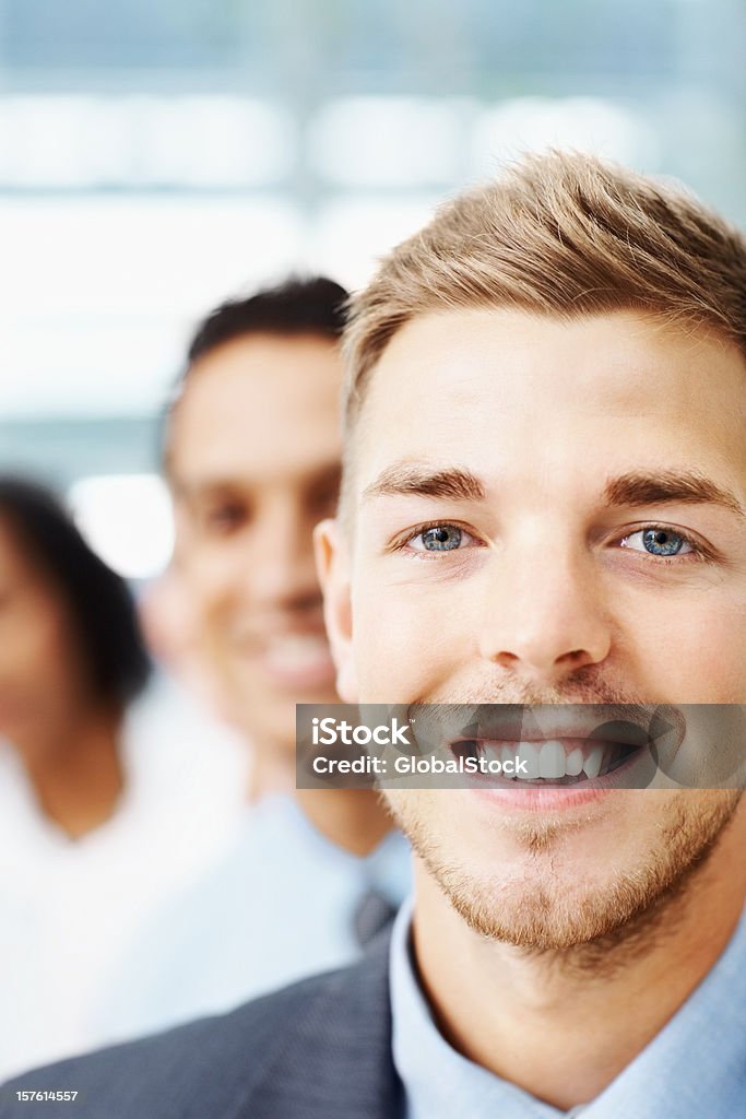 Sorridente jovem empresário com colegas no fundo - Royalty-free Profissão Foto de stock