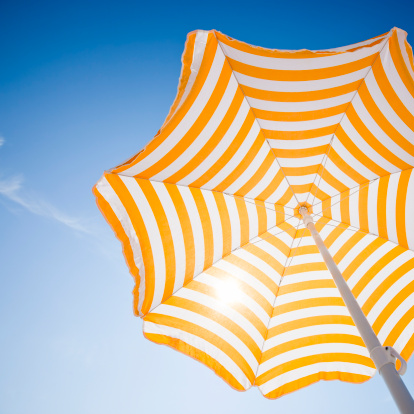 Beach umbrella against blue morning sky.  