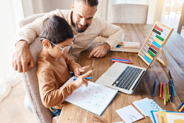 istock Learning, math education and father with kid in home with book for studying, homework or homeschool. Development, growth and boy or child with happy man teaching him how to count, bonding and care. 1576149204