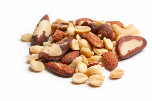 Assorted salted mixed nuts on white.