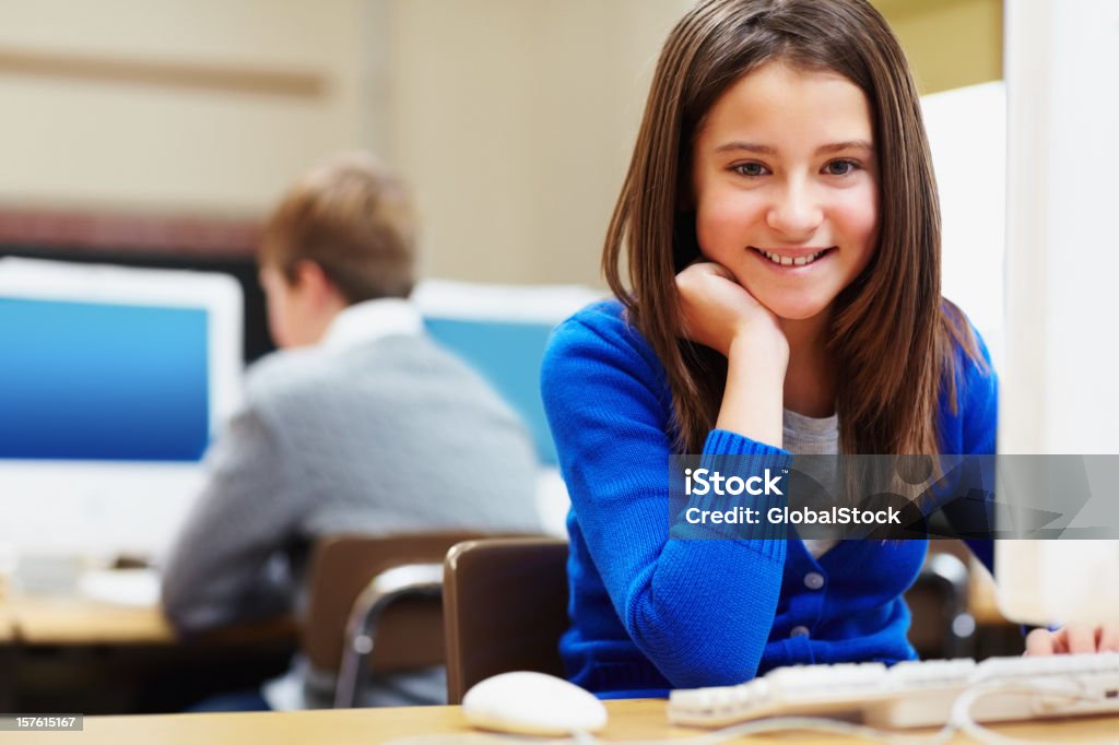 Souriant fille à l'aide d'ordinateur dans une salle de classe - Photo de 14-15 ans libre de droits