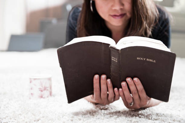Casually-dressed Christian guy holding his open Bible.