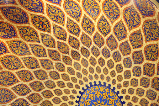 an abstract pattern inside a ceiling dome using the Islamic architectural style and decoration, this style most seen in the middle east and Persia..