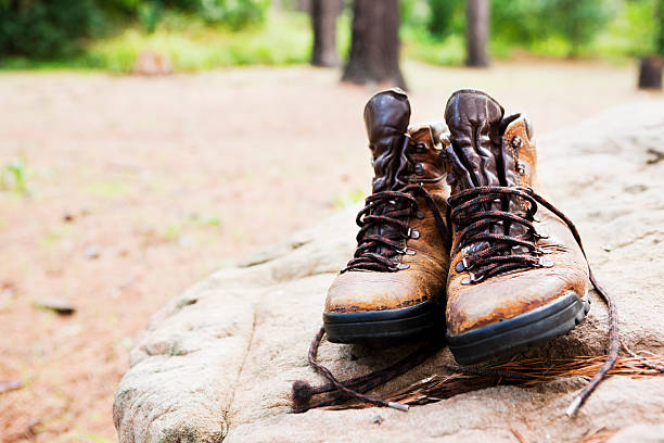 istock Battered hiking boots sit on a rock in forest clearing 157615663