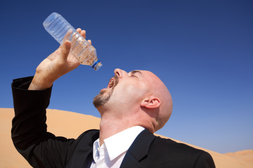 thirsty businessman trying to drink out of empty water bottle closehttp://www.amriphoto.com/istock/lightboxes/themes/desert.jpg