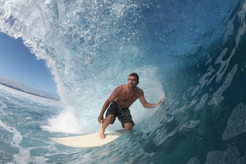 a surfer rides inside the barrel in fiji