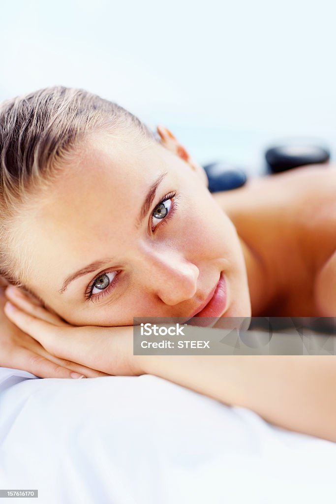 Beautiful female enjoying hot stone therapy at spa  20-24 Years Stock Photo
