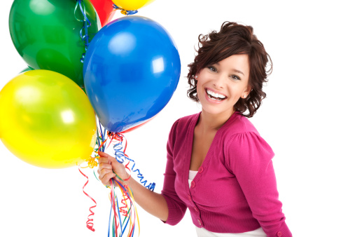 Photo of a young woman with a bunch of colorful party balloons; isolated on white.