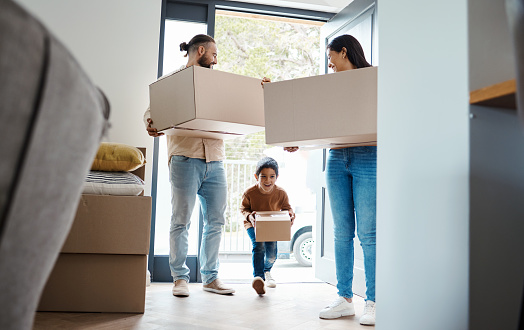 Family moving, new house and box with property, happy parents and child with real estate and home owner. Mortgage, people walking in front door and excited with love, relationship and relocation