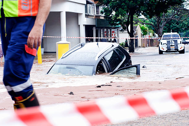 Oops! Car slipping into pothole in flooded street In a bizarre accident, a car slides into a pothole in a flooded street. Shot with Canon EOS 1Ds Mark III. sinkhole stock pictures, royalty-free photos & images