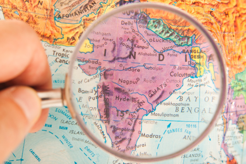Studying Geography - Photo of India and surrounding countries on retro globe. Under a magnifying glass.  