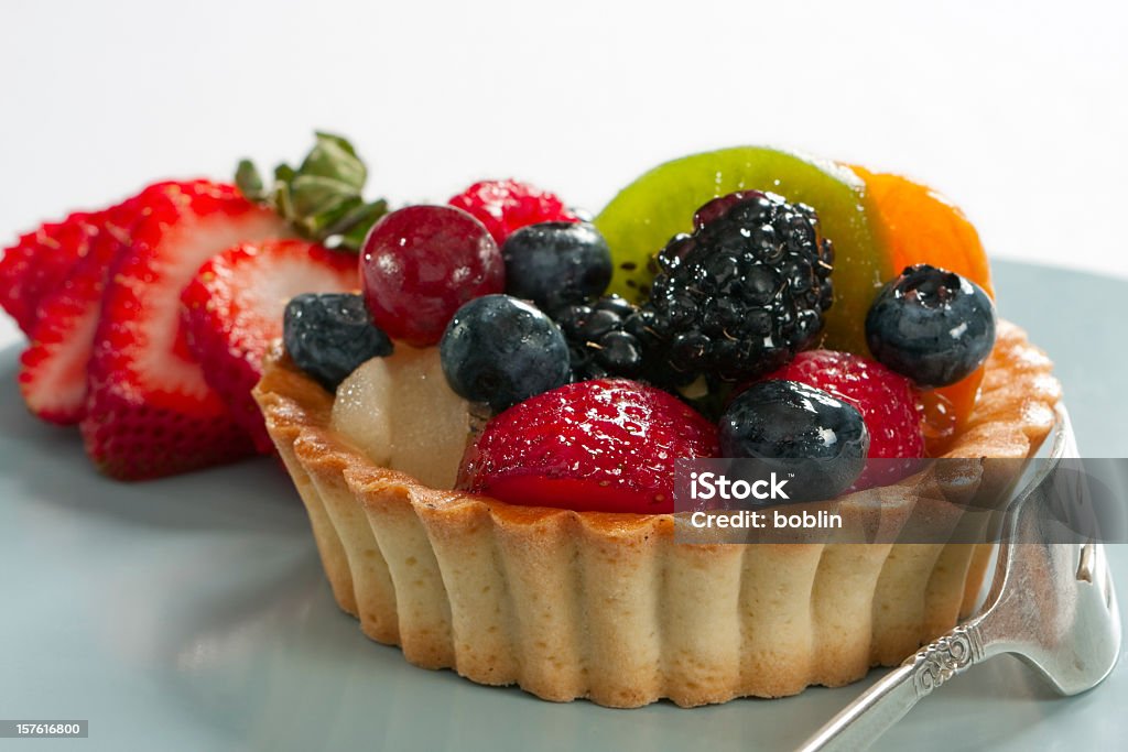 Blueberry kiwi strawberry individual tart A delicious fruit tart made with strawberries, blueberries, grapes, blackberries, mango and kiwi. Tart - Dessert Stock Photo