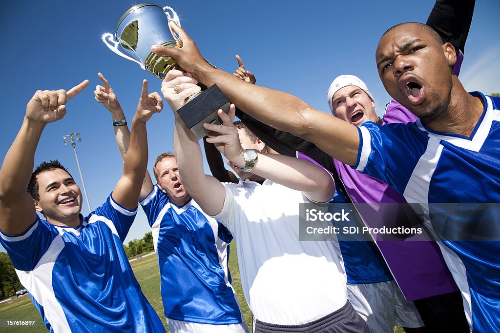 Trofeo sosteniendo un equipo de fútbol juntos después de la victoria - Foto de stock de Aclamar libre de derechos