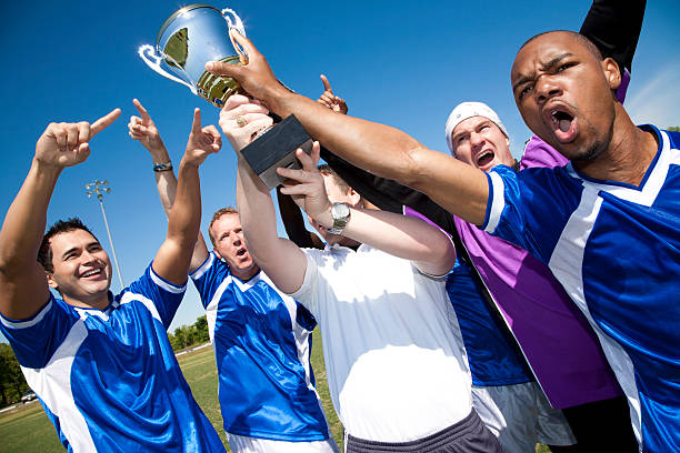 istock Soccer Team Holding Up Trophy Together after Victory 157616897