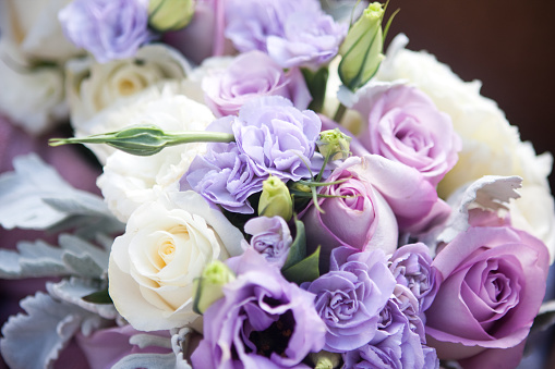 A brides purple and white rose bouquet.