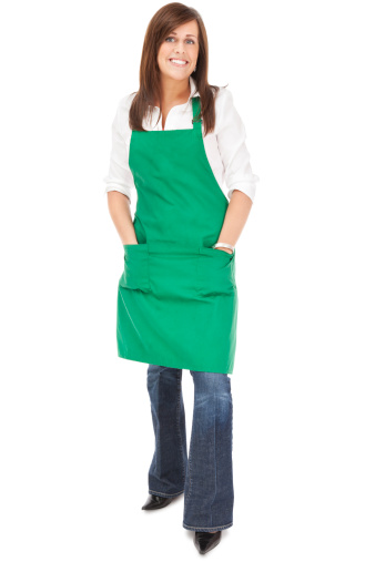 Photo of an attractive young woman wearing a green apron; isolated on white.