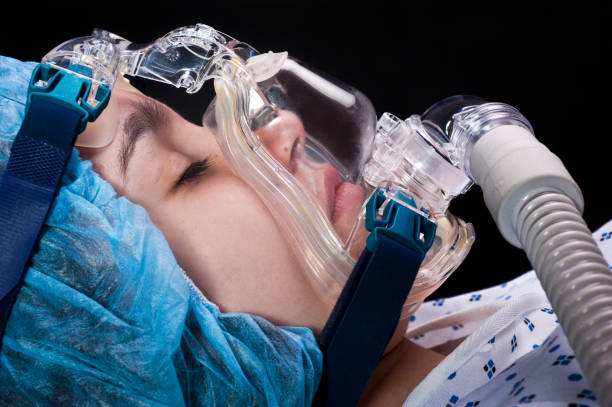 Child sleeping using a breathing device teenage girl sleeping using a breathing device on black background (this picture has been taken with a Hasselblad H3D II 31 megapixels camera) 13 14 years child teenage girls lying down stock pictures, royalty-free photos & images