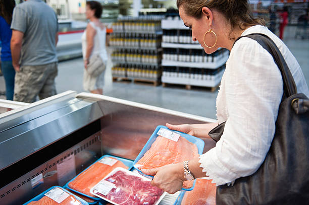 buying fresh salmon - mature woman having fish bildbanksfoton och bilder