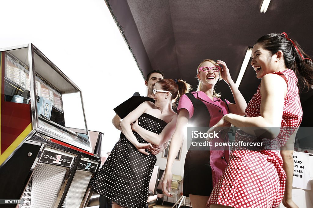 Retro 1950's Friends Dancing by the Jukebox in Soda Shop Retro Young adults dancing by the jukebox 1950-1959 Stock Photo