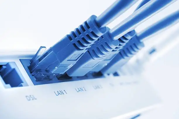 close up of a lan switch with pluged in cables, blue toned image, shallow depth of field